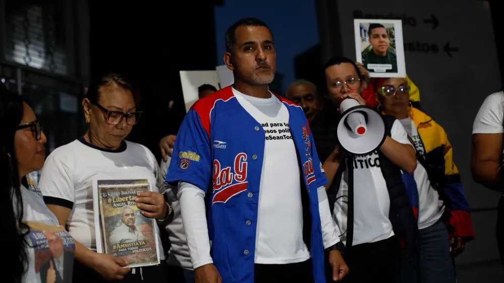 Opposition figure Juan Freites, center, stands with relatives of people they consider political prisoners, after his release from El Helicoide, an intelligence headquarters and detention center, in Caracas, Venezuela, Sunday, Feb. 22, 2026. (AP Photo/Cristian Hernandez)