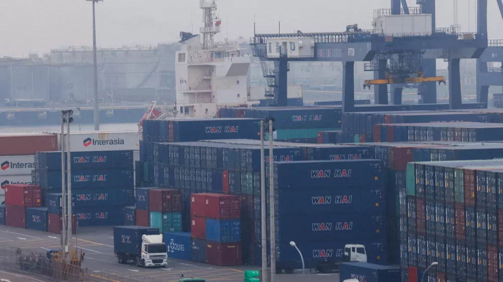 FILE PHOTO: FILE PHOTO: Trucks drive between cargo containers at Port of Taichung in Taichung, Taiwan April 18, 2023. REUTERS/Ann Wang/File Photo/File Photo