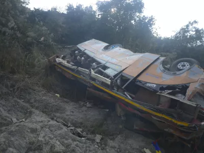 The wreckage of a bus is seen on the bank of the Trishuli River after it drove off a mountain highway near Benighat, west of the capital, Kathmandu, Nepal, Monday, Feb. 23, 2026. (AP Photo/Bijay Rai)