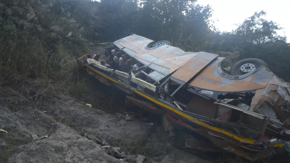 The wreckage of a bus is seen on the bank of the Trishuli River after it drove off a mountain highway near Benighat, west of the capital, Kathmandu, Nepal, Monday, Feb. 23, 2026. (AP Photo/Bijay Rai)