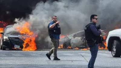 Police officers secure the area where vehicles were set on fire by organized crime members to block a road following a military operation in which a government source said Mexican drug lord Nemesio Oseguera, commonly known as "El Mencho," was killed, in Zapopan, Mexico, February 22, 2026. REUTERS/Gilberto Gallo   TPX IMAGES OF THE DAY