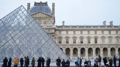 FILE - People wait for the Louvre museum to open as employees at the Louvre Museum vote to extend a strike that has disrupted operations at the world's most visited museum, Dec. 18, 2025 in Paris. (AP Photo/Thibault Camus, File)