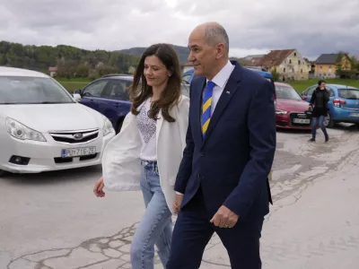 Slovenia's Prime Minister Janez Jansa with his wife Urska Bacovnik Jansa walks away from a polling station in Sentilj, Slovenia, Sunday, April 24, 2022. Slovenians cast ballots in a parliamentary election that is expected to be a tight race between Prime Minister Janez Jansa's ruling right-wing populists and liberals in the politically divided European Union nation. (AP Photo/Darko Bandic)