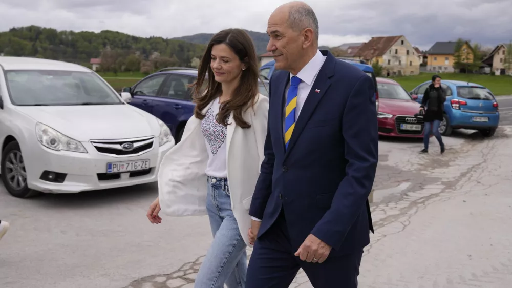 Slovenia's Prime Minister Janez Jansa with his wife Urska Bacovnik Jansa walks away from a polling station in Sentilj, Slovenia, Sunday, April 24, 2022. Slovenians cast ballots in a parliamentary election that is expected to be a tight race between Prime Minister Janez Jansa's ruling right-wing populists and liberals in the politically divided European Union nation. (AP Photo/Darko Bandic)
