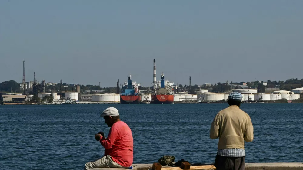 Men fish in Havana Bay across from the Nico Lopez oil refinery, as the U.S. Treasury Department said it would authorize companies seeking licenses to resell Venezuelan oil to Cuba, in Havana, Cuba February 25, 2026. REUTERS/Norlys Perez