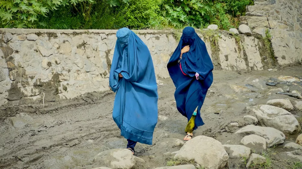 FILE PHOTO: Afghan women in burqa walk towards a safer place after their house was damaged following a deadly magnitude 6 earthquake that struck Afghanistan on Sunday, at Lulam village, in Nurgal district, Kunar province, Afghanistan, September 3, 2025. REUTERS/Sayed Hassib/File Photo