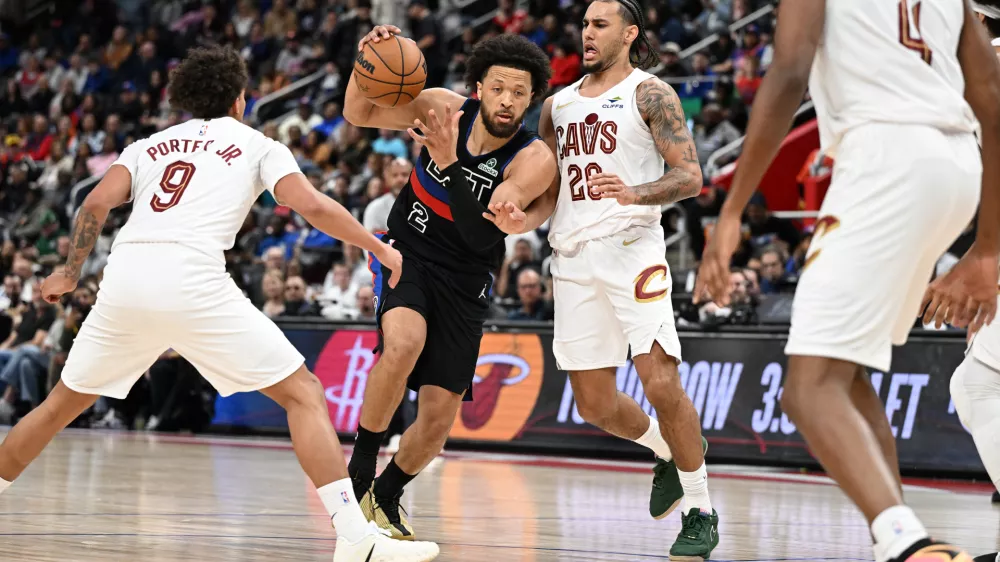 Feb 27, 2026; Detroit, Michigan, USA; Detroit Pistons guard Cade Cunningham (2) tries to drive between Cleveland Cavaliers guard Craig Porter Jr. (9) and Cleveland Cavaliers guard Jaylon Tyson (20) in the first half at Little Caesars Arena. Mandatory Credit: Lon Horwedel-Imagn Images