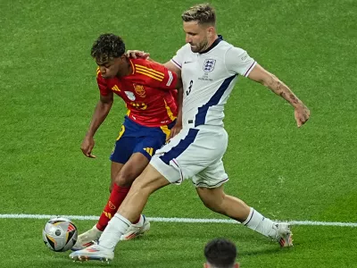 14 July 2024, Berlin: England's Luke Shaw and Spain's Lamine Yamal battle for the ball during the UEFA Euro 2024 final soccer match between Spain and England at the Olympic Stadium. Photo: Michael Kappeler/dpa