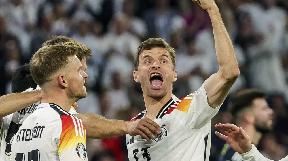 FILE - Germany's Thomas Mueller, right, celebrates during the Group A match between Germany and Scotland at the Euro 2024 soccer tournament in Munich, Germany, Friday, June 14, 2024. Germany forward Thomas M&uuml;ller has announced his retirement from international soccer after a 14-year career that included the 2014 World Cup title. (Christian Charisius/dpa via AP, File)