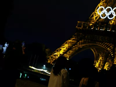 Tourists take pictures of the Eiffel Tower a day before the opening ceremony of the Paris 2024 Olympics, in Paris, France June 25, 2024. REUTERS/Agustin Marcarian