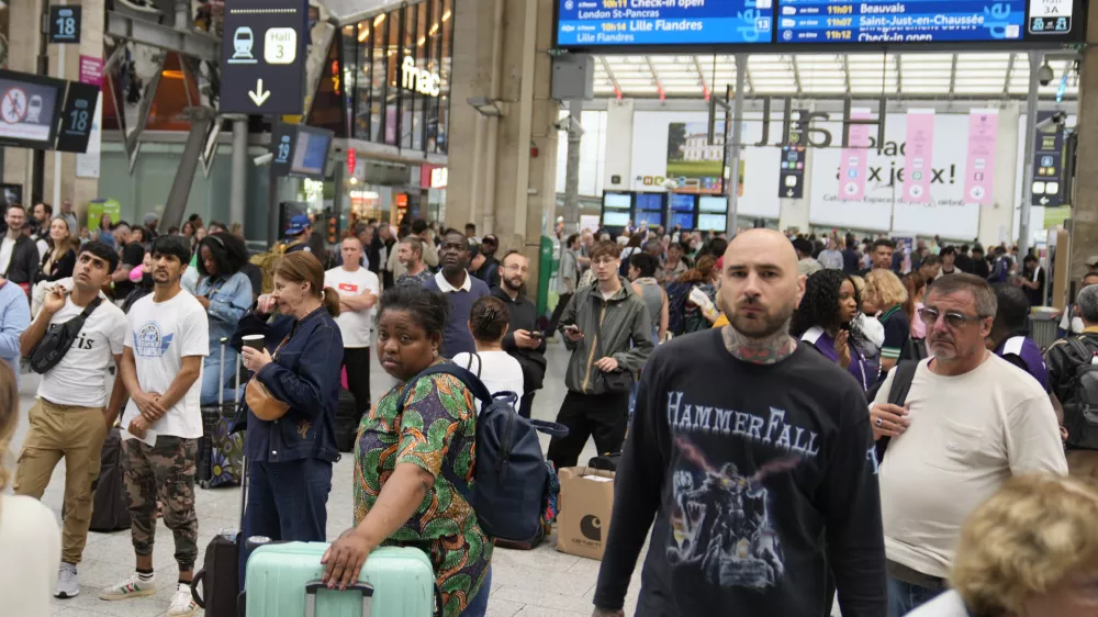 Travelers wait inside the Gare du Nord train station at the 2024 Summer Olympics, Friday, July 26, 2024, in Paris, France. Hours away from the grand opening ceremony of the Olympics, high-speed rail traffic to the French capital was severely disrupted on Friday by what officials described as "criminal actions" and sabotage. (AP Photo/Mark Baker)