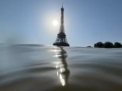30 July 2024, France, Paris: The Eiffel Tower pictured behind the Seine  men's triathlon at the Paris Olympics was postponed until 31 July because the Seine is still not deemed clean enough to swim in. Photo: Jan Woitas/dpa