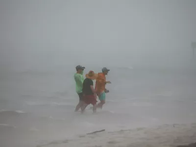 04 August 2024, US, Tampa: People venture into the shallows off the Dunedin Causeway, as a squall of storms inundates the area with wind and rain as Tropical Storm Debby passes the Tampa Bay area offshore. Photo: Douglas R. Clifford/Tampa Bay Times/ZUMA Press Wire/dpa