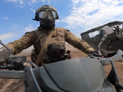In this photo taken from video released by Russian Defense Ministry Press Service on Monday, Aug. 12, 2024, a marine assault team member rides motorcycle toward Ukrainian position at an undisclosed location. (Russian Defense Ministry Press Service photo via AP)