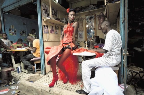 Manekenka pozira pred krojaškimi delavnicami v središču Dakarja med 9.  dakarskim tednom mode.