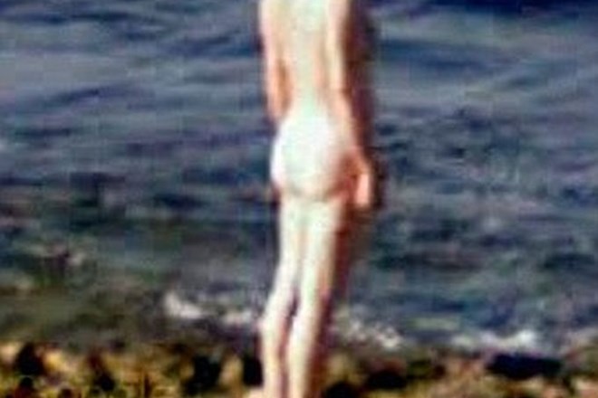 Gola ženska ob morju.
