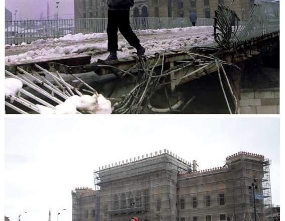 Moški na zgornji fotografiji, ki je bila posneta 1.1.1994, nosi vrečo polen za kurjavo čez uničen most v bližini požgane...