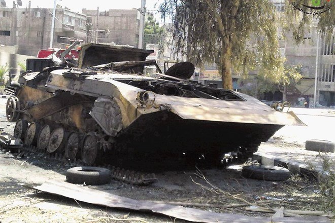 Uničeno oklepno vozilo sirske armade v predmestju Damaska, ki so ga uporniki zapustili po srditih spopadih.