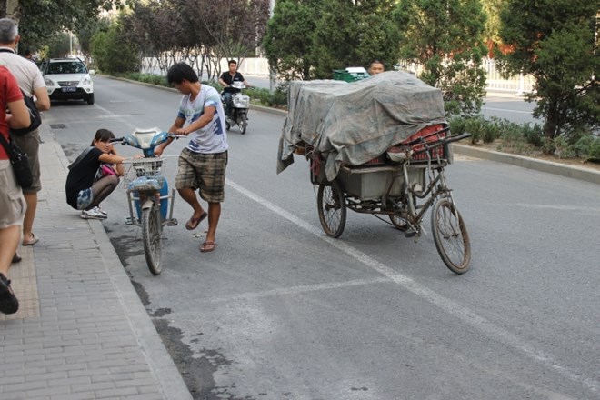 Mladenič je na kolesarski stezi ustavil svoj kolo-kamion in kavalirsko pomagal dekletu, ki ji je obmolknil skuter.