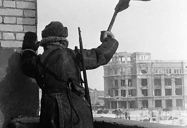 Prizor ob osvojenem Stalingradu: Sovjetski vojak maha z zastavo (foto: Reuters) 