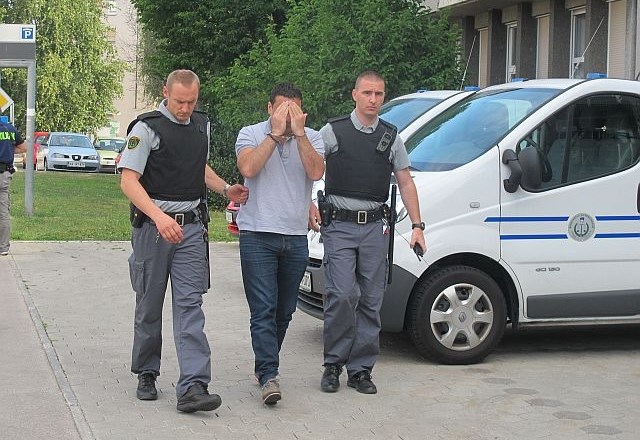 Velibor Popović, ki ga varujeta oborožena policista. (foto: Miran Šubic) 