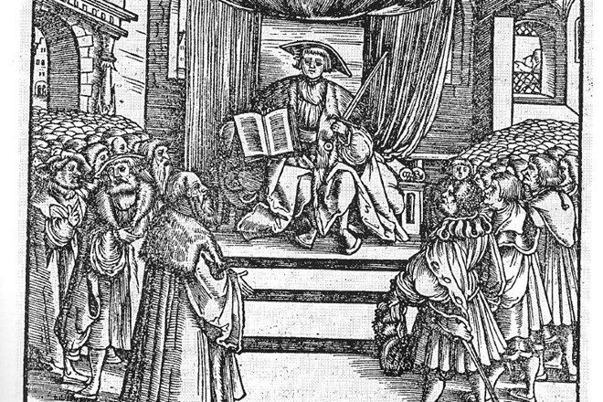 Cesar Karel V. s kazenskim zakonikom iz leta 1532, v katerem je bilo čarovništvo prvič uradno opredeljeno kot zločin in zanj...