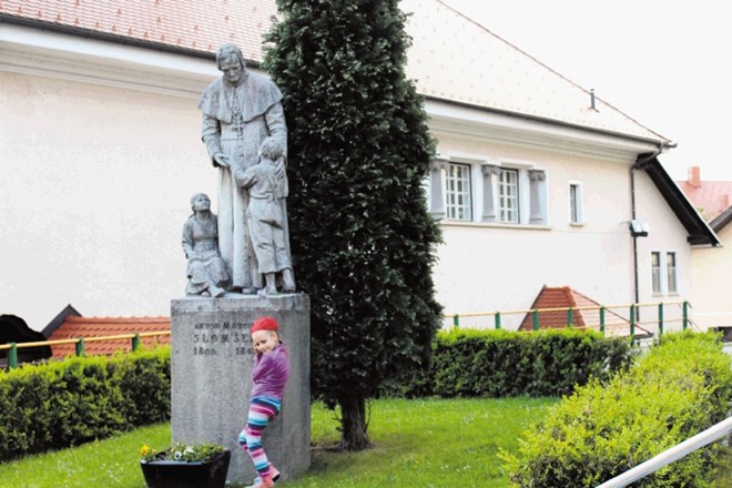 Osemletna Karolina pred spomenikom Antona Martina Slomška 