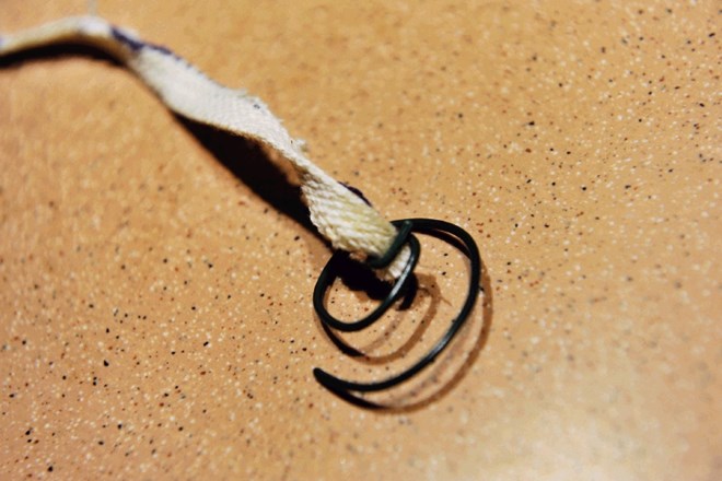 Stenj pritrdimo na žico, ki ga bo med vlivanjem stopljenega voska držala na dnu kozarca.  