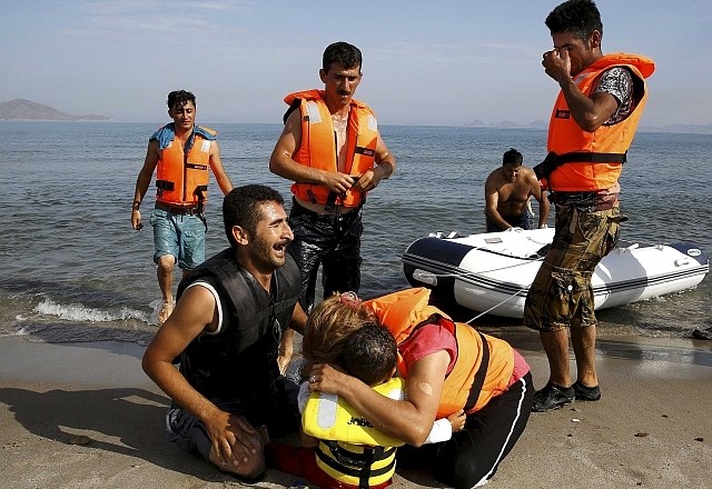 Veselje migrantov, ko so s čolna stopili na trdna tla. (Foto: Reuters) 