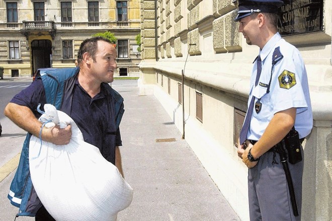 Andrej Podpečan leta 2002 med predajo vreče podcenjene pšenice takratnemu predsedniku vlade Janezu Drnovšku. 