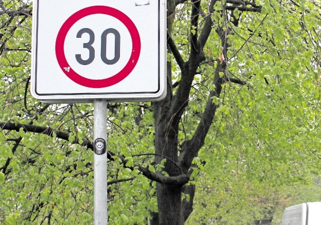 Začetek območja omejene hitrosti označuje pravokotni znak z napisom cona in narisanim znakom za omejitev hitrosti na 30 km/h...