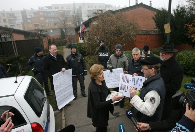 Pred hišo Milana Kučana protestiralo okoli 10 ljudi in poskušalo zažgati biografijo