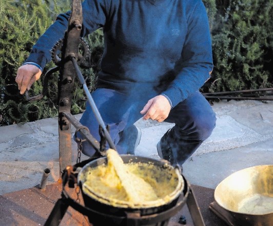 Joško Sirk ob kuhanju polente, ki se je ob v zemljanki in kraški jami zorjenih sirih odlično podala k penini. 