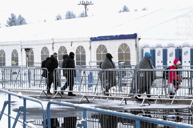 Vsakodnevni prizor v sprejemnem centru v Dobovi. Kolona beguncev se počasi, skozi mraz in sneg pomika proti avtobusom, ki jih...
