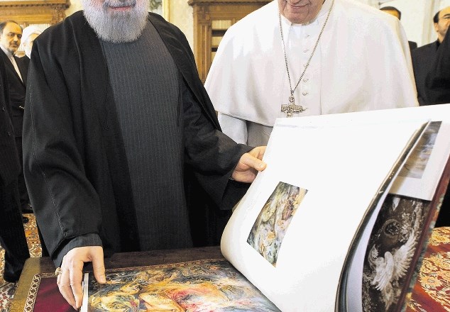 Iranski predsednik Rohani razkazuje papežu knjigo, ki mu jo je podaril. 