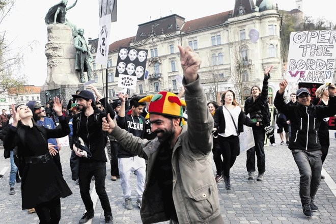 Prosilci za azil, ki so si tako kot drugi protestniki nadeli maske s podobo Janeza Janše in Mira Cerarja, so na Prešernovem...