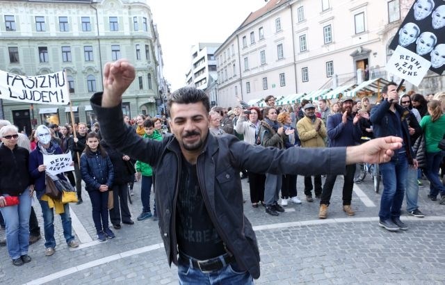 Prosilci za azil, ki so si tako kot drugi protestniki nadeli maske s podobo Janeza Janše in Mira Cerarja, so na Prešernovem...