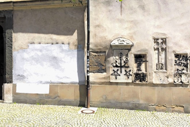 Fasado cerkve so vandali popisali žaljivimi grafiti.