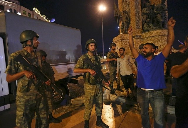 Turška vojska in domnevni Erdoganovi podporniki na Taksimu. (Foto: Reuters)