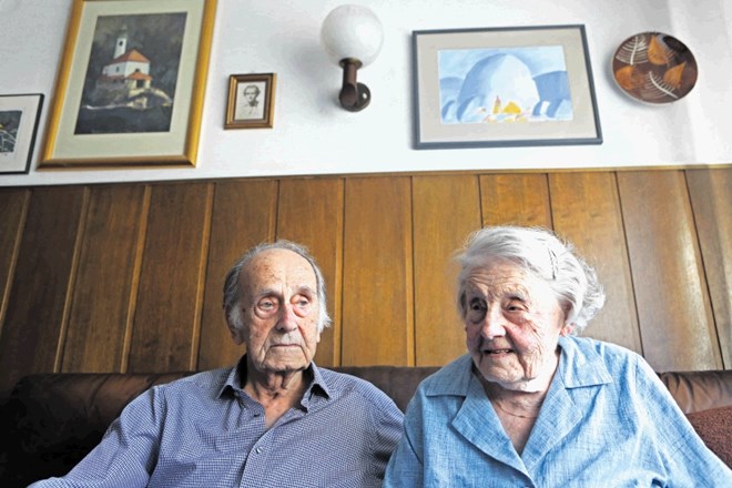Jože in Ivica Pogačnik v svoji dnevni sobi pod slikama Kamnika, kjer sta se spoznala.