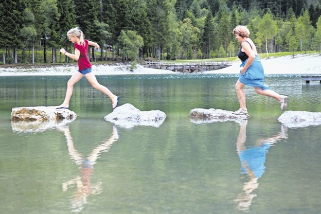 Babica in vnukinja sta se zabavali tako, da sta s skoki s kamna na kamen prečkali del jezera Jasna. (Foto: Maja Marko)