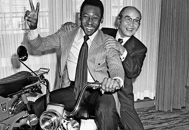 Posnetek iz leta 1976: Soičiru Hondi na motorju dela družbo brazilski nogometni zvezdnik Pele, ki je s Hondo podpisal...
