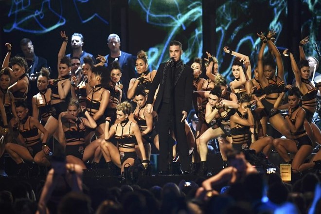 Robbieju Williamsu so na odru delale družbo lepotice. (Foto: Reuters)