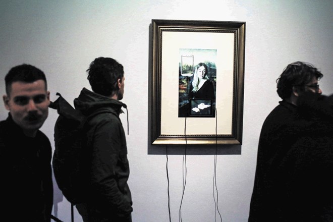 Na zaslonu baročno uokvirjenega dela Muzej Lowres da Vincijevo muzo zamenja kar Dorotea Škrabo, mobilne naprave z naloženimi...