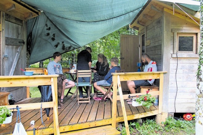 Družina Škerbot iz Voličine si je v kampu Alpe omislila začasno streho, da so lahko zunaj zajtrkovali tudi v dežju.