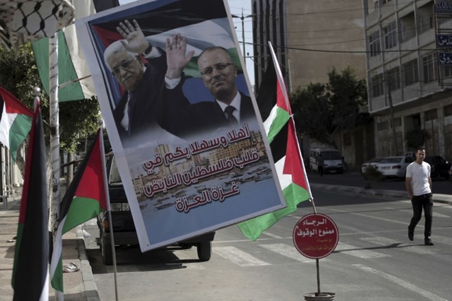 Na ulici v Gazi je v nedeljo visel poster, na katerem sta palestinski predsednik Mahmud Abas and premier Rami Hamdalah