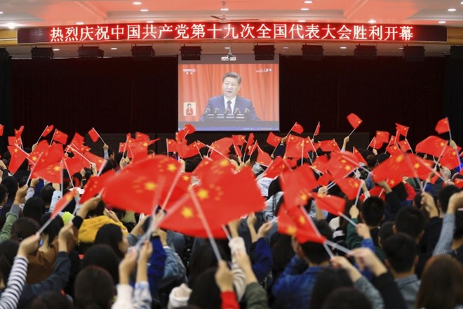 Študentje z zastavicami ob spremljanju govora kitajskega predsednika na včerajšnji otvoritvi kongresa stranke.