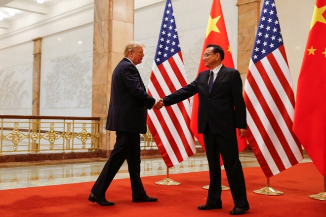 Donald Trump se rokuje s kitajskim predsednikom vlade Li Keqiangom med obiskom v Pekingu.
