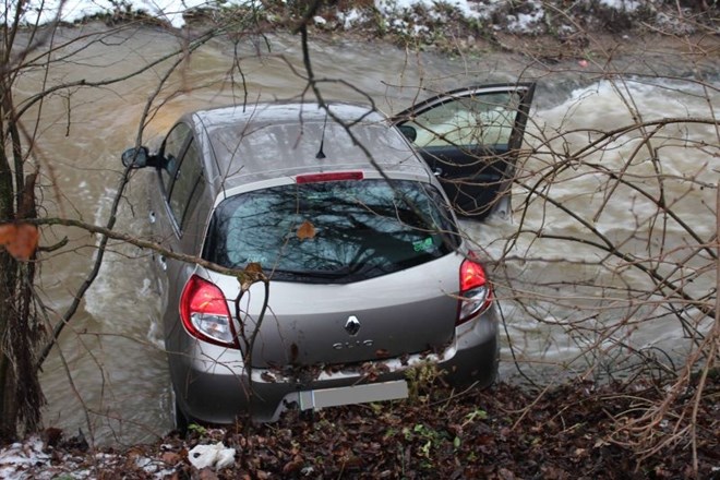 Avtomobil voznice na škofjeloškem območju, ki je zaradi poledenelosti zdrsnil v deroč potok.