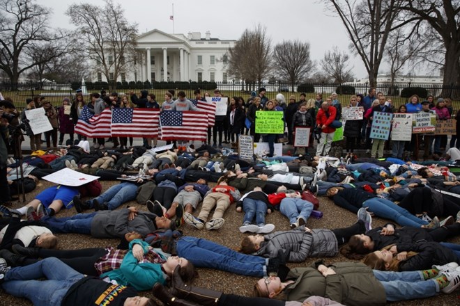 Mladi zagovorniki reforme zakonodaje o nadzoru prodaje orožja so se polegli na tla pred Belo hišo, medtem ko je predsednik...